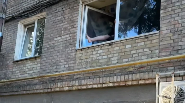 Нога неадекватного чоловіка у вікні. Фото: скриншот із відео