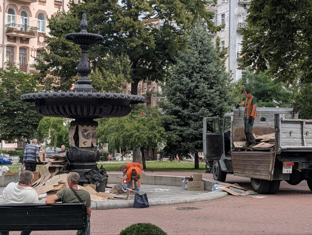 Комунальники прибирають картонні плакати. Фото: The Page